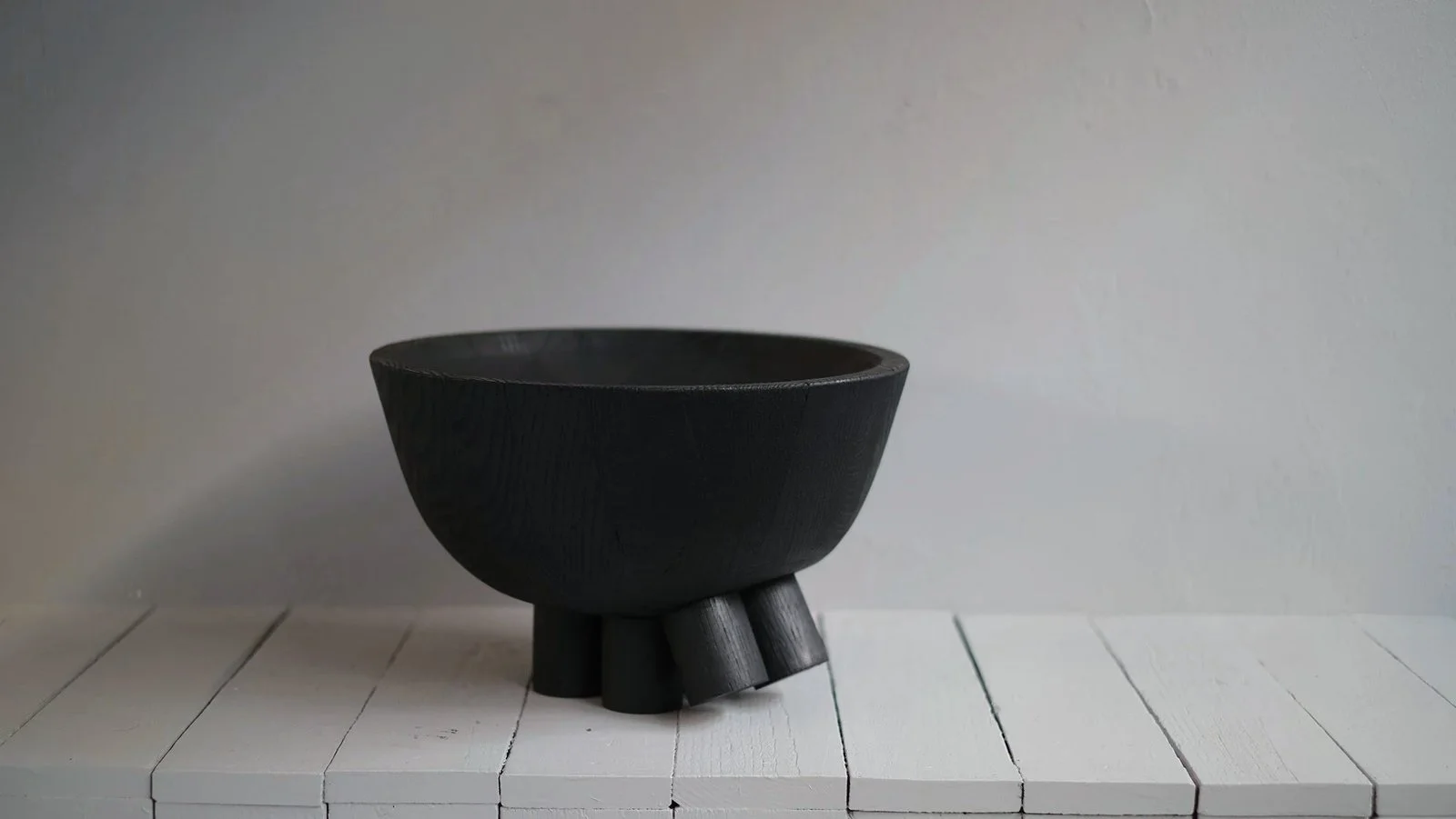 Closer view of the burned oak bowl and sculptural feet of the Walking Bowl by Arno Declercq.