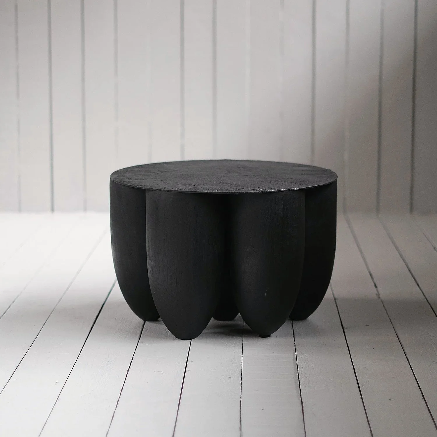 Closer view of the rounded Iroko base and circular top of the Senufo Coffee Table by Arno Declercq.