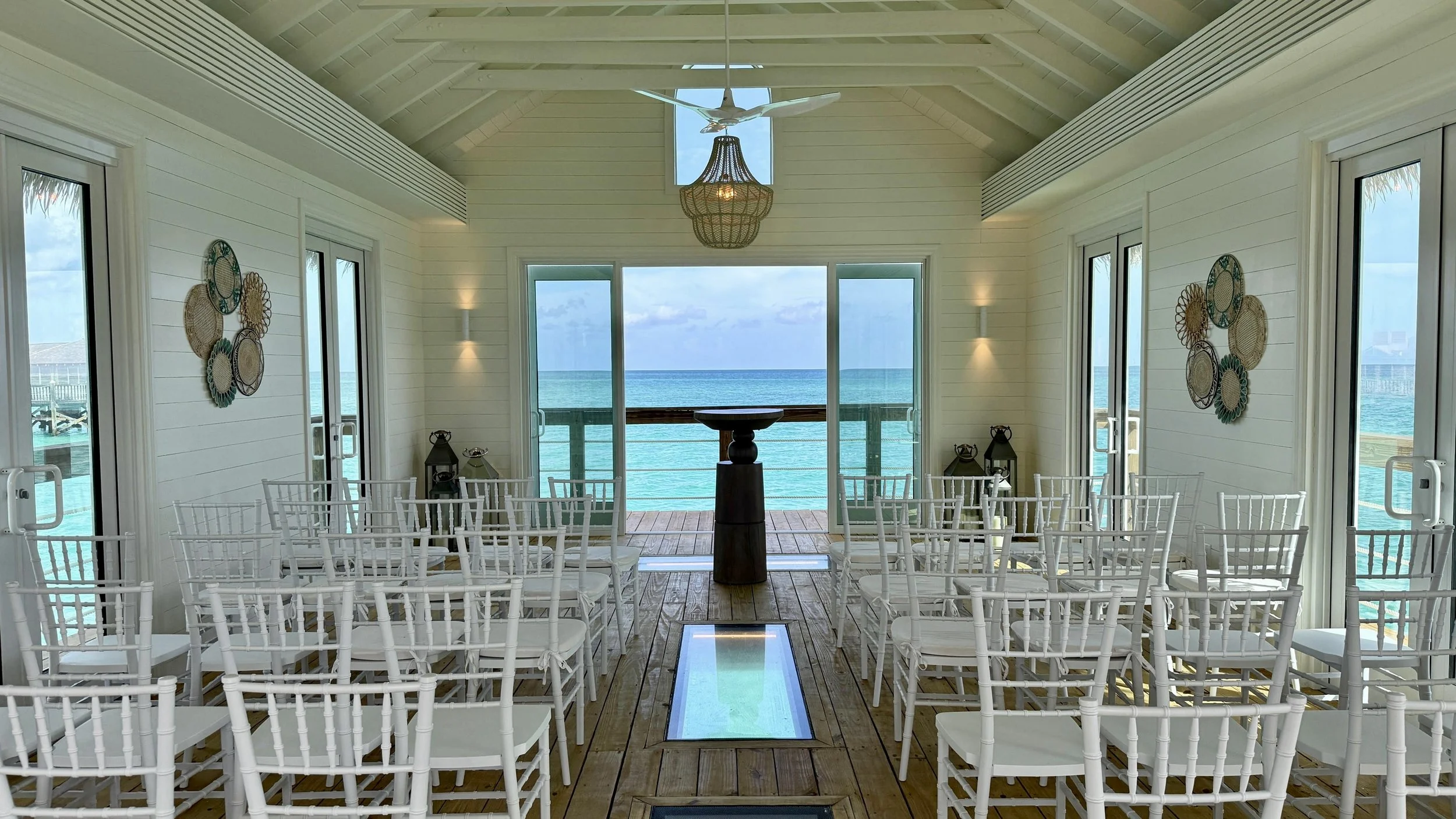 Over the water destination wedding ceremony venue with bright water reflections