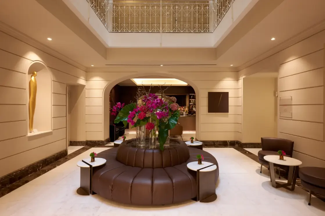 Lobby atrium at The First Arte with a round leather banquette