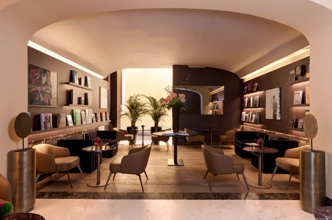 Vaulted lounge at The First Arte with backlit art book shelves