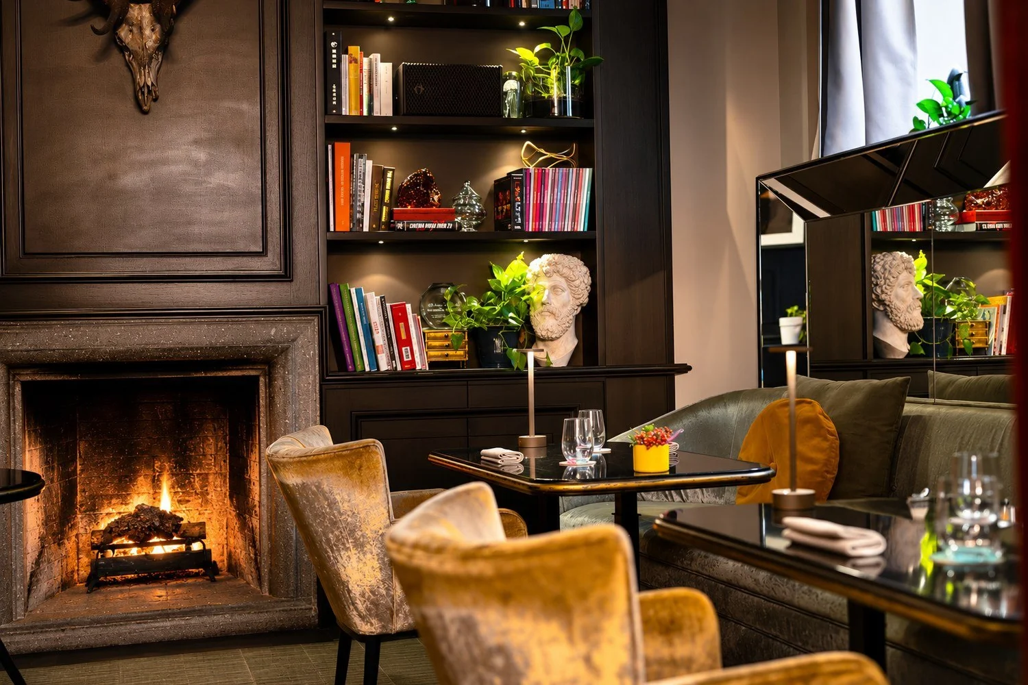 Lounge at D.O.M Hotel with a fireplace and velvet armchairs