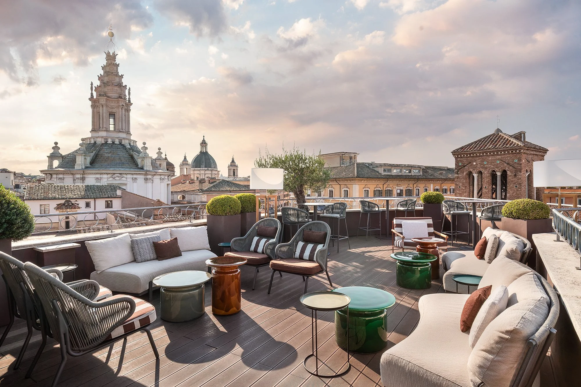 The Divinity rooftop terrace at The Pantheon Iconic Rome Hotel at sunset, with the domes of Rome behind