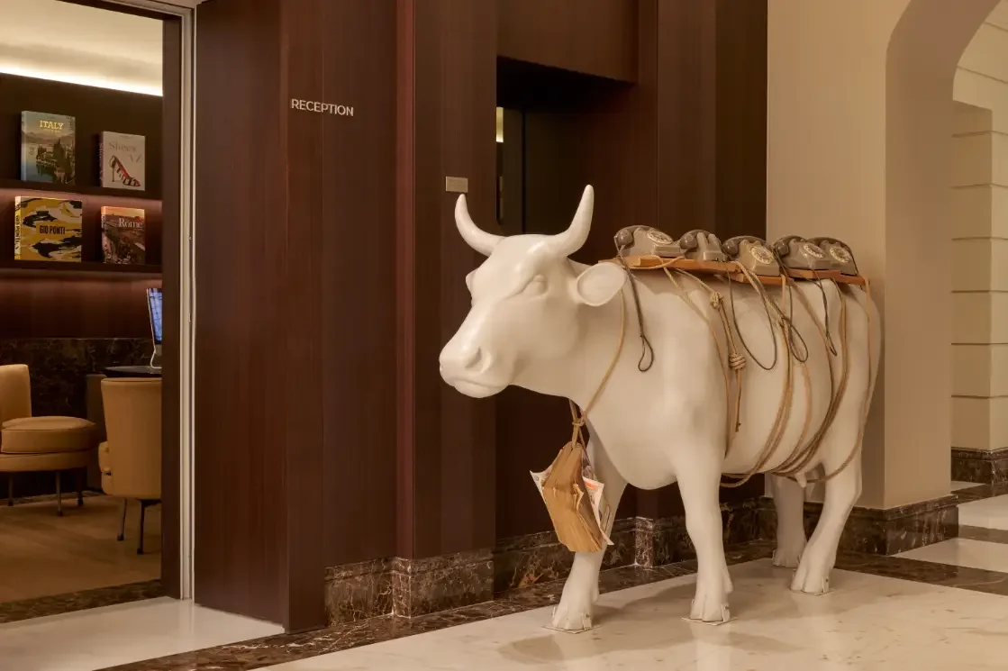 Life-size cow sculpture by the reception at The First Arte