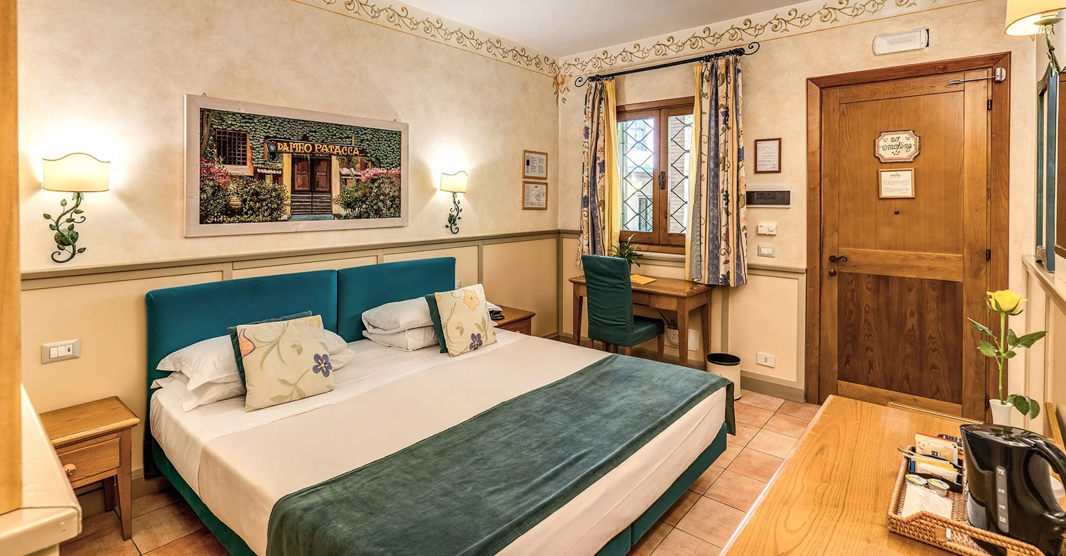 Guest room at Hotel Santa Maria with a teal velvet headboard