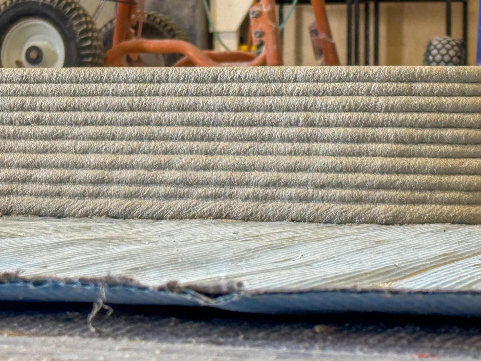 Close view of stacked material-extrusion layers in a printed wall section.