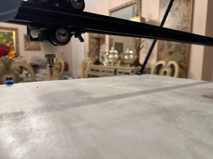 Low-angle indoor view of the prototype gantry and metal test bed.