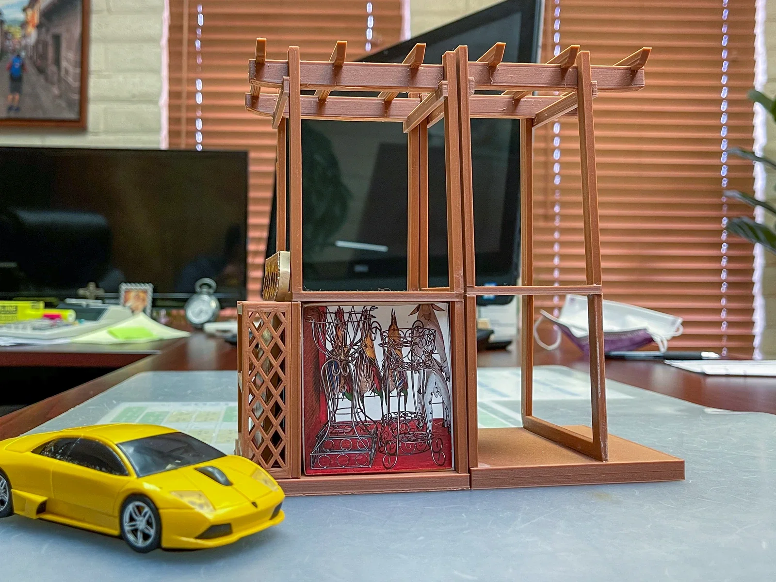 Wood-filament scale model of the Rustic Pavilion Display beside a yellow model car.