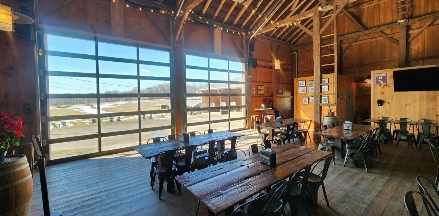 The taproom's glass garage doors looking out on the farm in winter