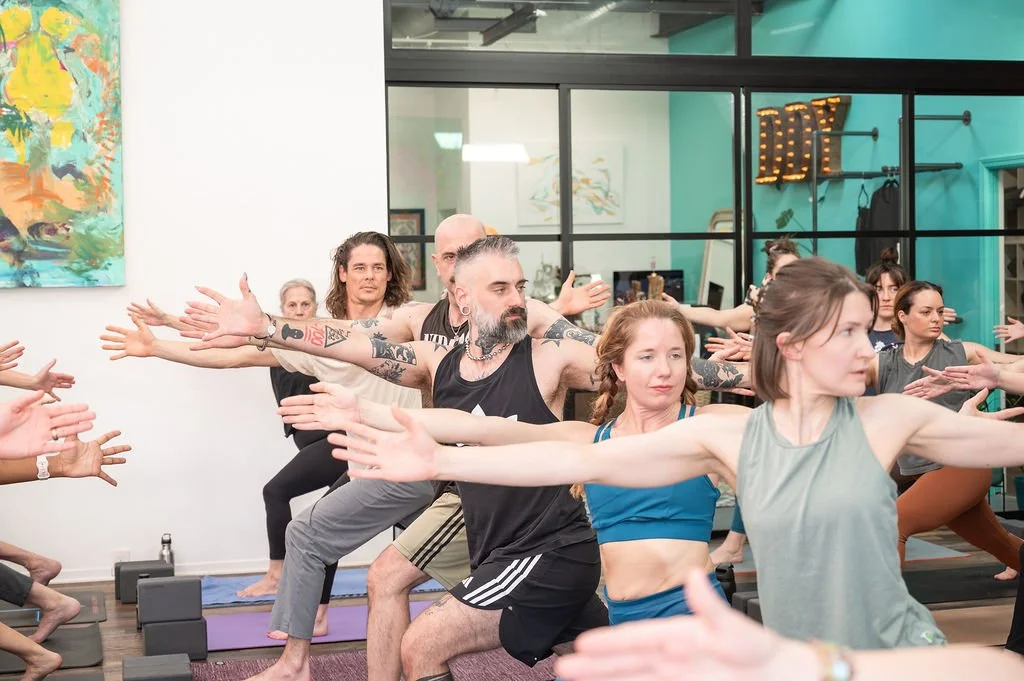 Advanced yoga teacher trainees practicing warrior pose together at Dancing Dogs Yoga