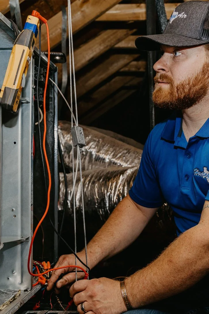 A guy checking air system outside of the house at heritageairtx