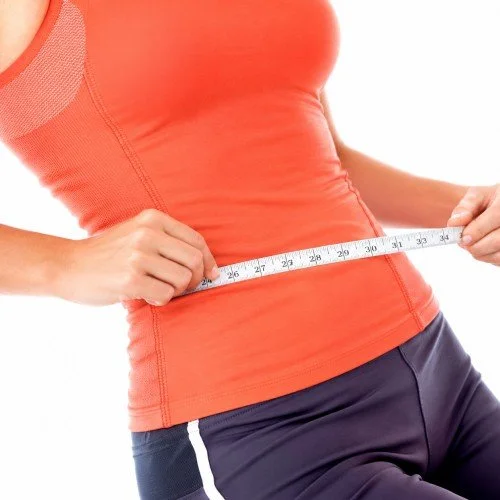 Person measuring their waist with a measuring tape