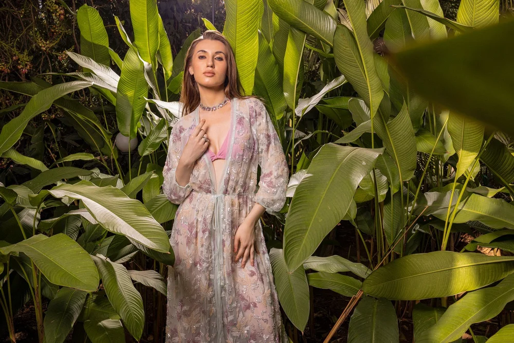 Alexandrite Aura Kimono with floral beadwork, photographed among tropical leaves.