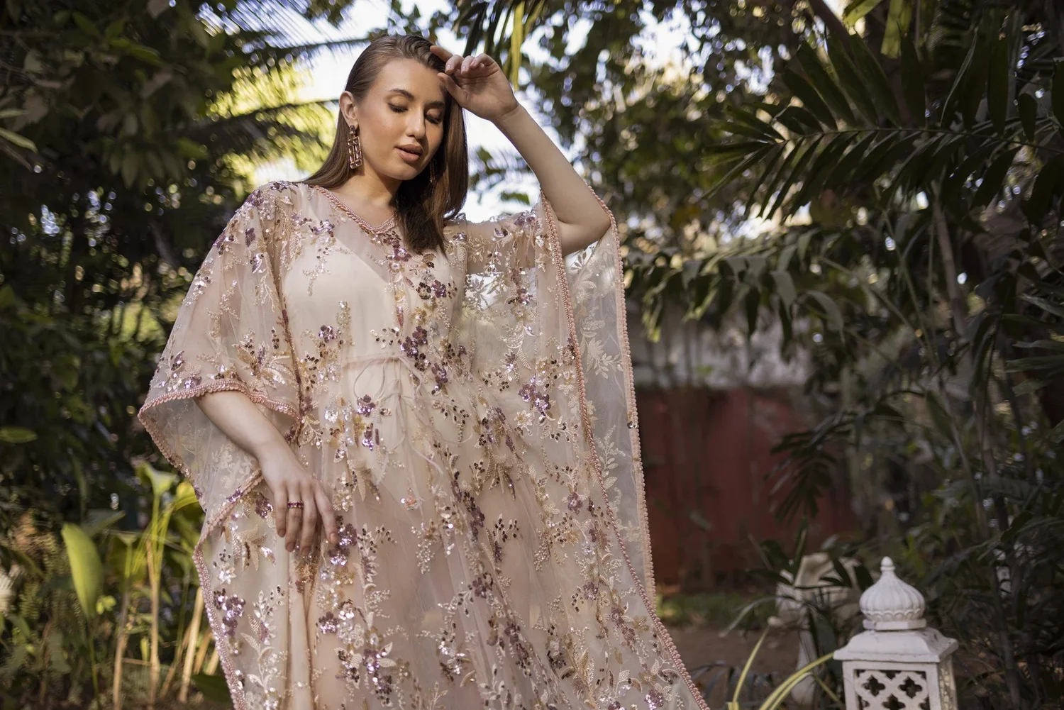 Model wearing the finished Pink Sapphire Blossom Kaftan in a tropical garden.