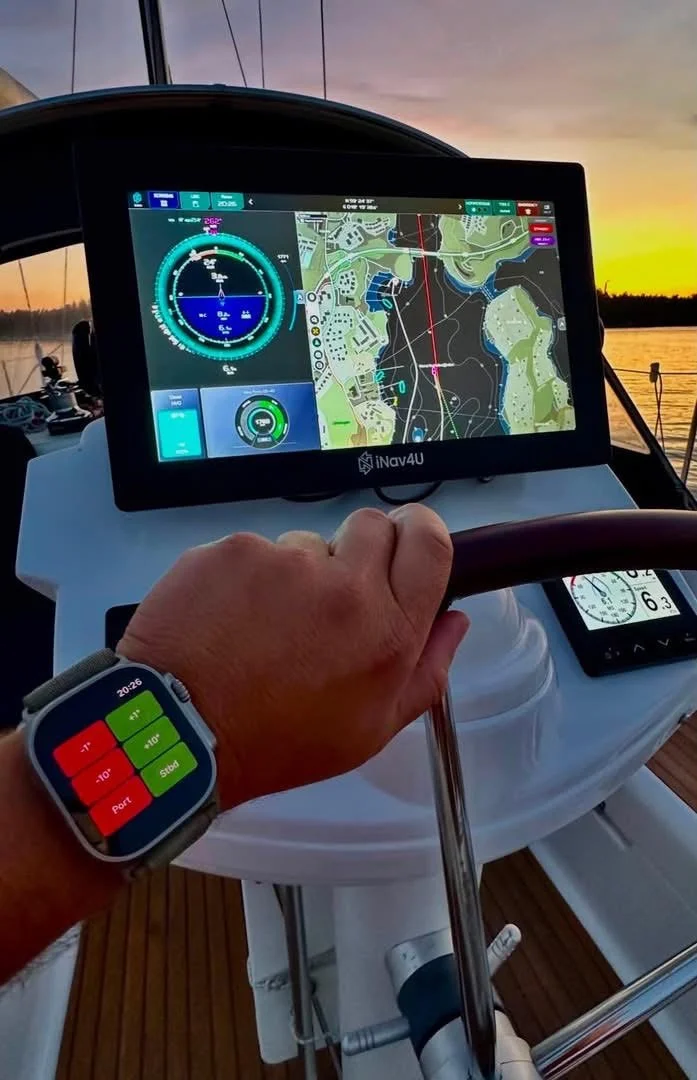 Hand on the wheel, smartwatch and Zora at the helm at sunset