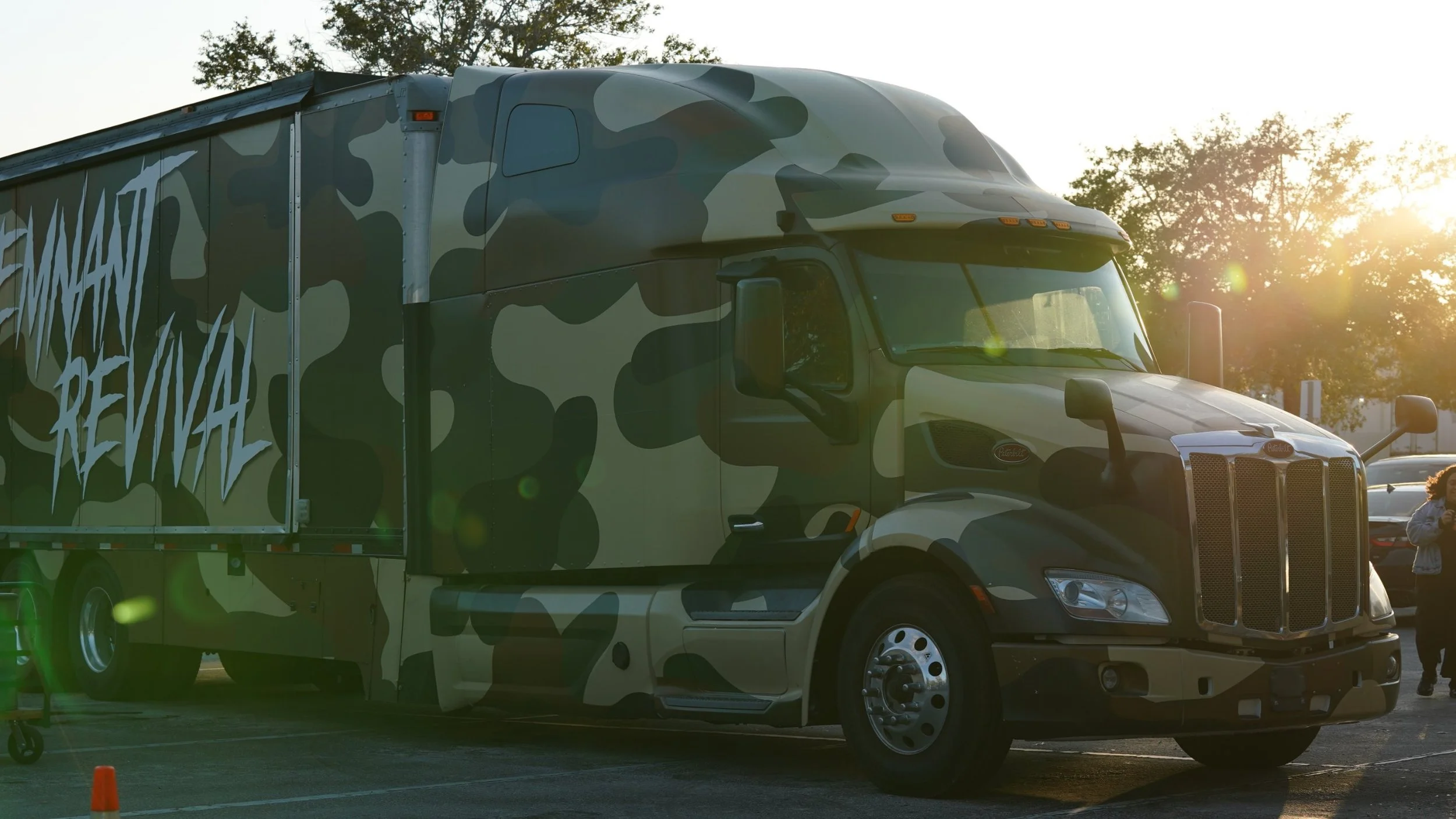 The Remnant Revival Tours truck, wrapped in camouflage, parked at sunset
