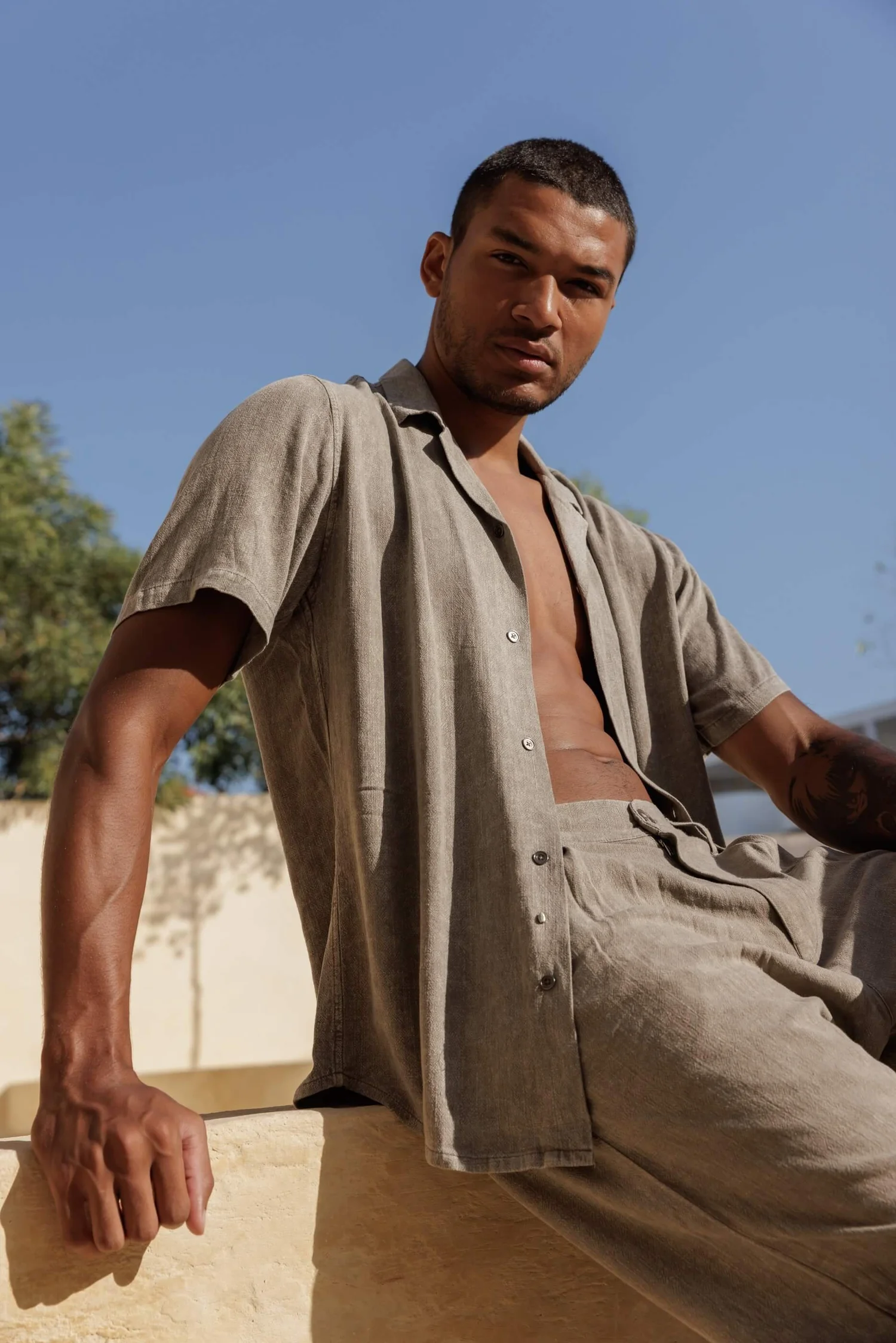 Man wearing Nousa Concept SS26 beige linen shirt and trousers, Mediterranean atmosphere