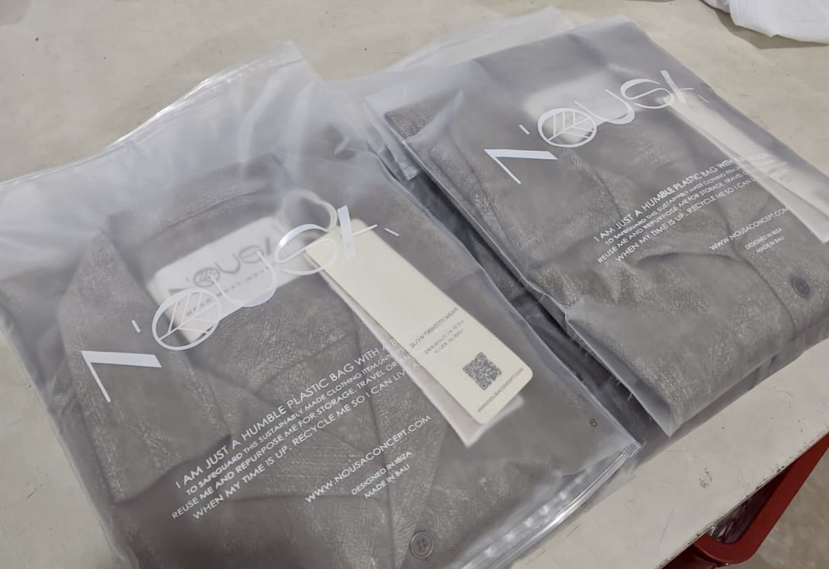 Finished Nousa Concept garments folded and packed with woven hangtags, ready to ship