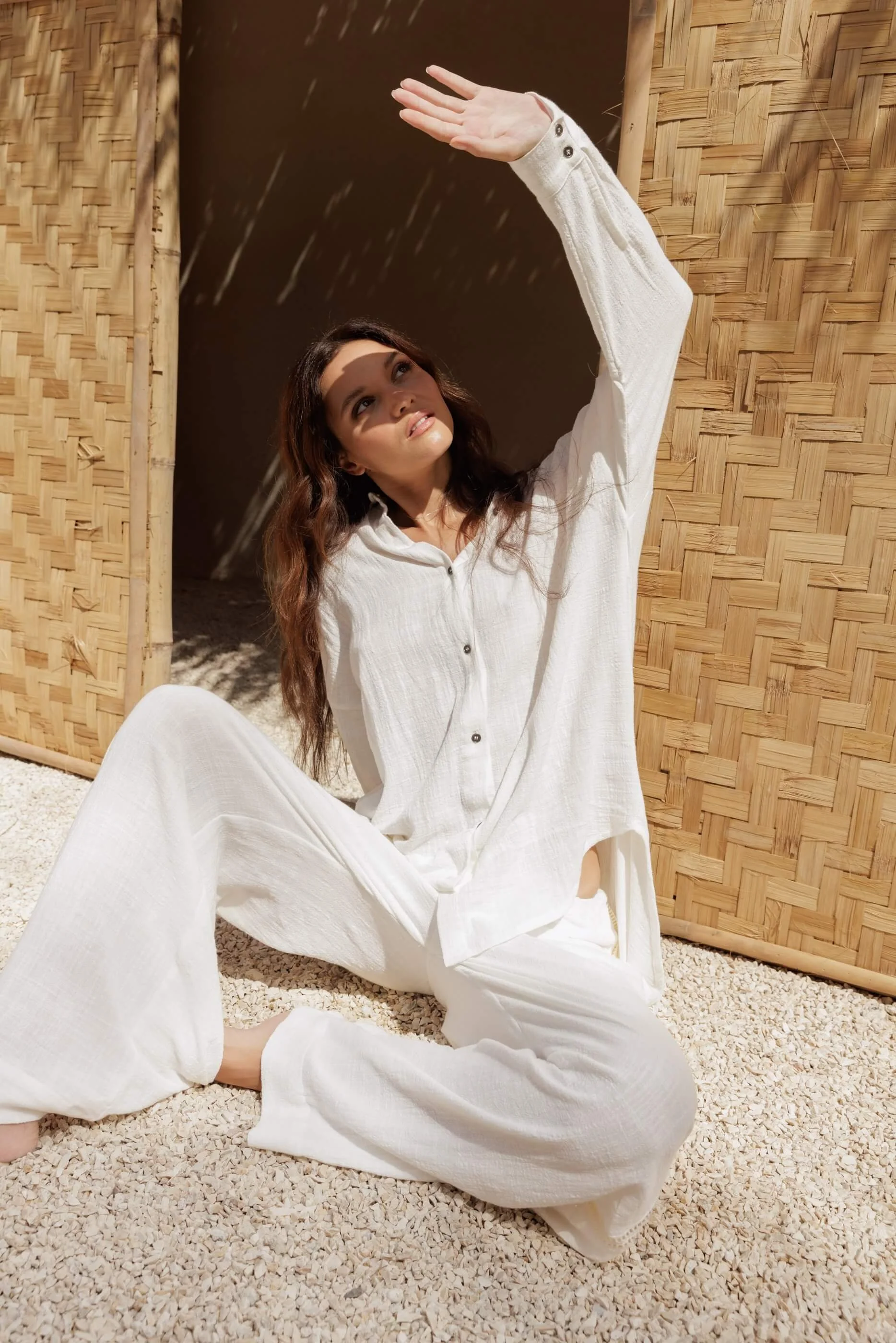 Woman in white cotton set in Nousa Concept Bali workshop, bamboo wall and natural light