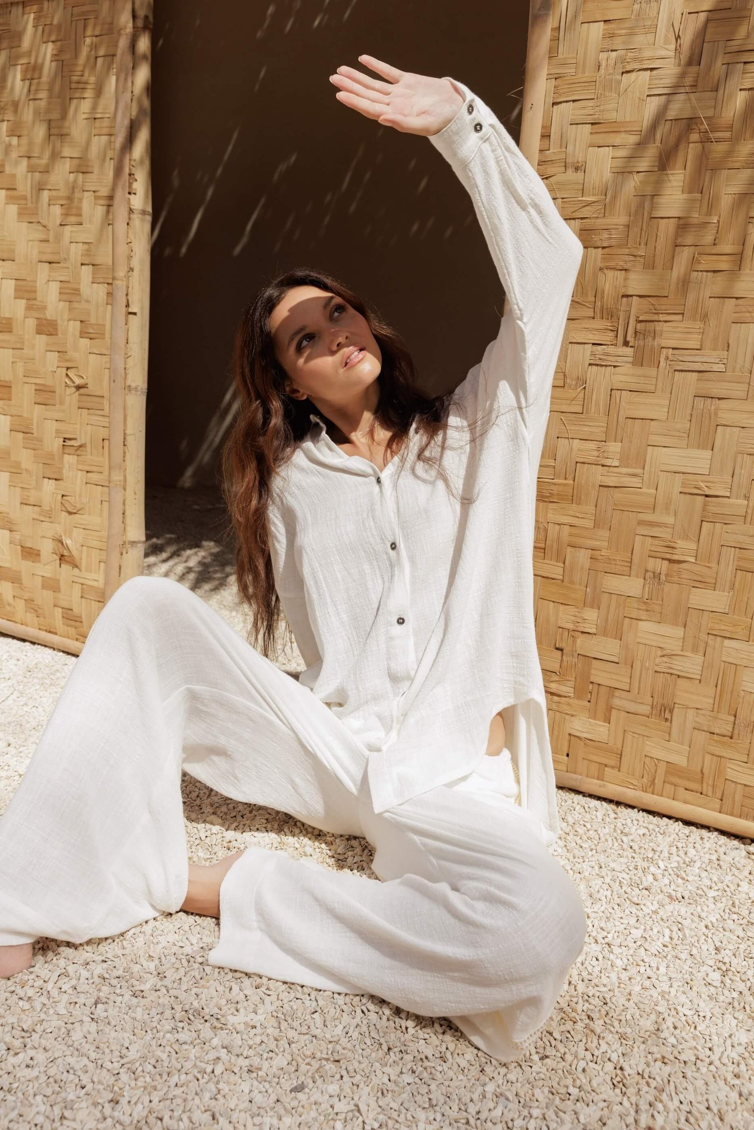 Woman in white cotton set in Nousa Concept Bali workshop, bamboo wall and natural light