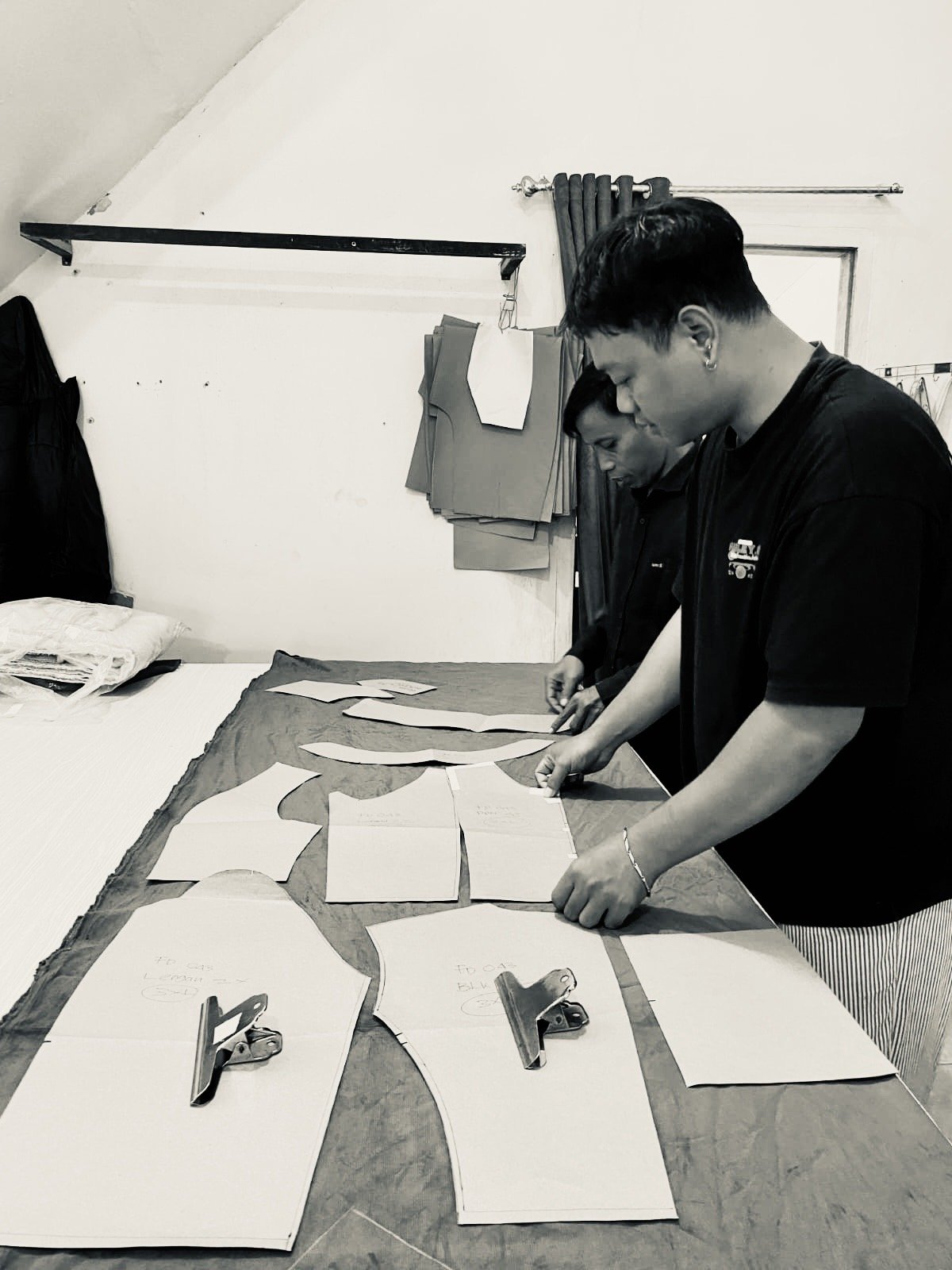 Tailor cutting paper patterns for a Nousa Concept garment in Bali