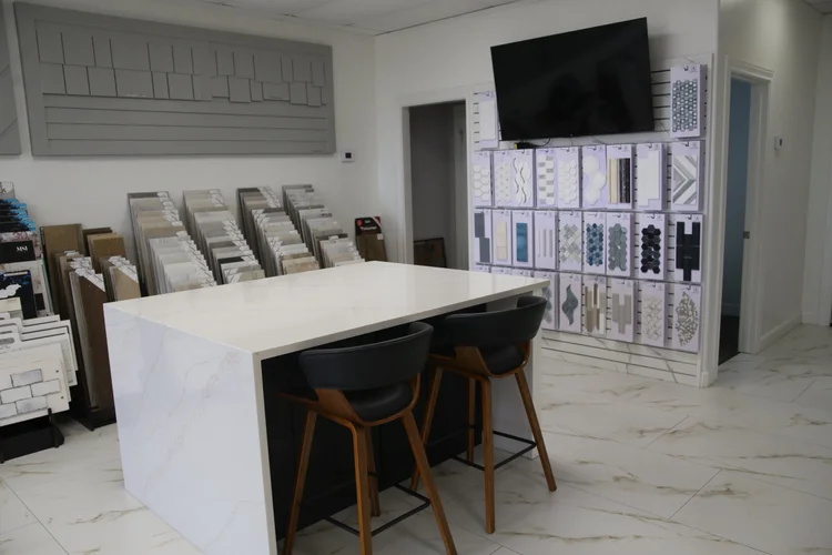 Design island with stools beneath a wall of tile samples