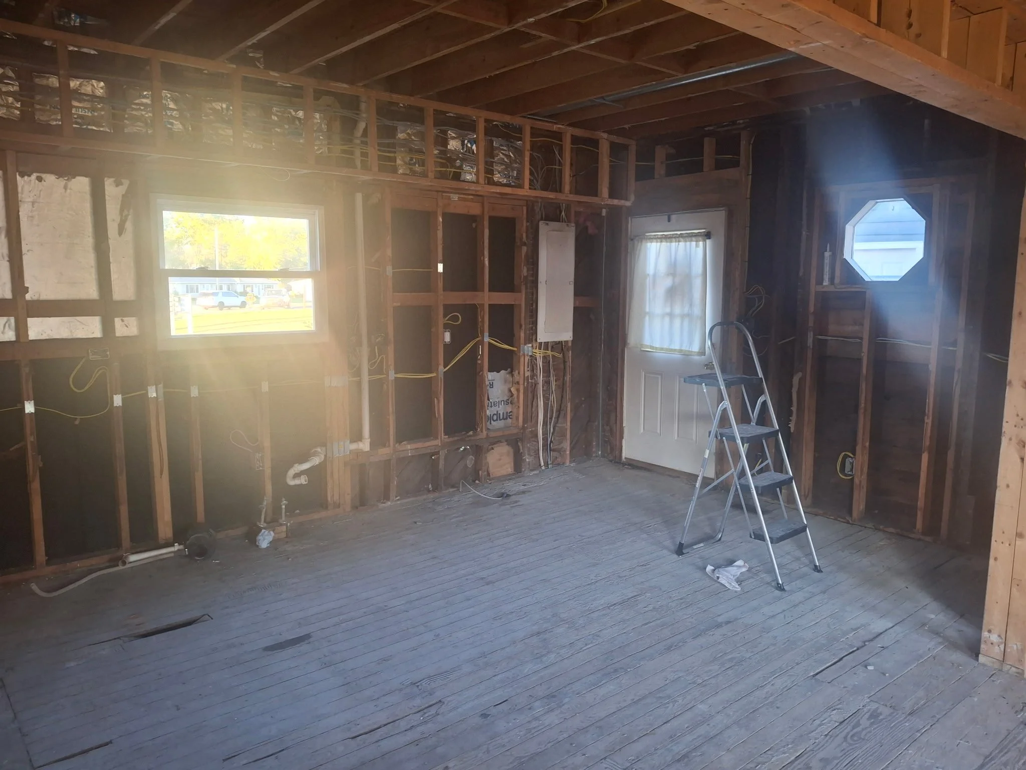 Interior of the parsonage showing exposed framing and utilities following demolition.