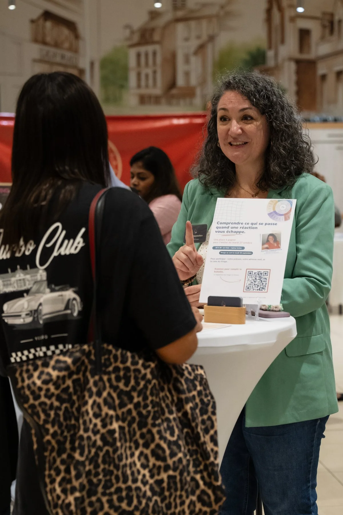 Aurélie Giammeluca, psychopraticienne, à son stand du Forum de l'Entrepreneuriat Féminin AUDACE à Gagny, en train d'échanger avec une visiteuse