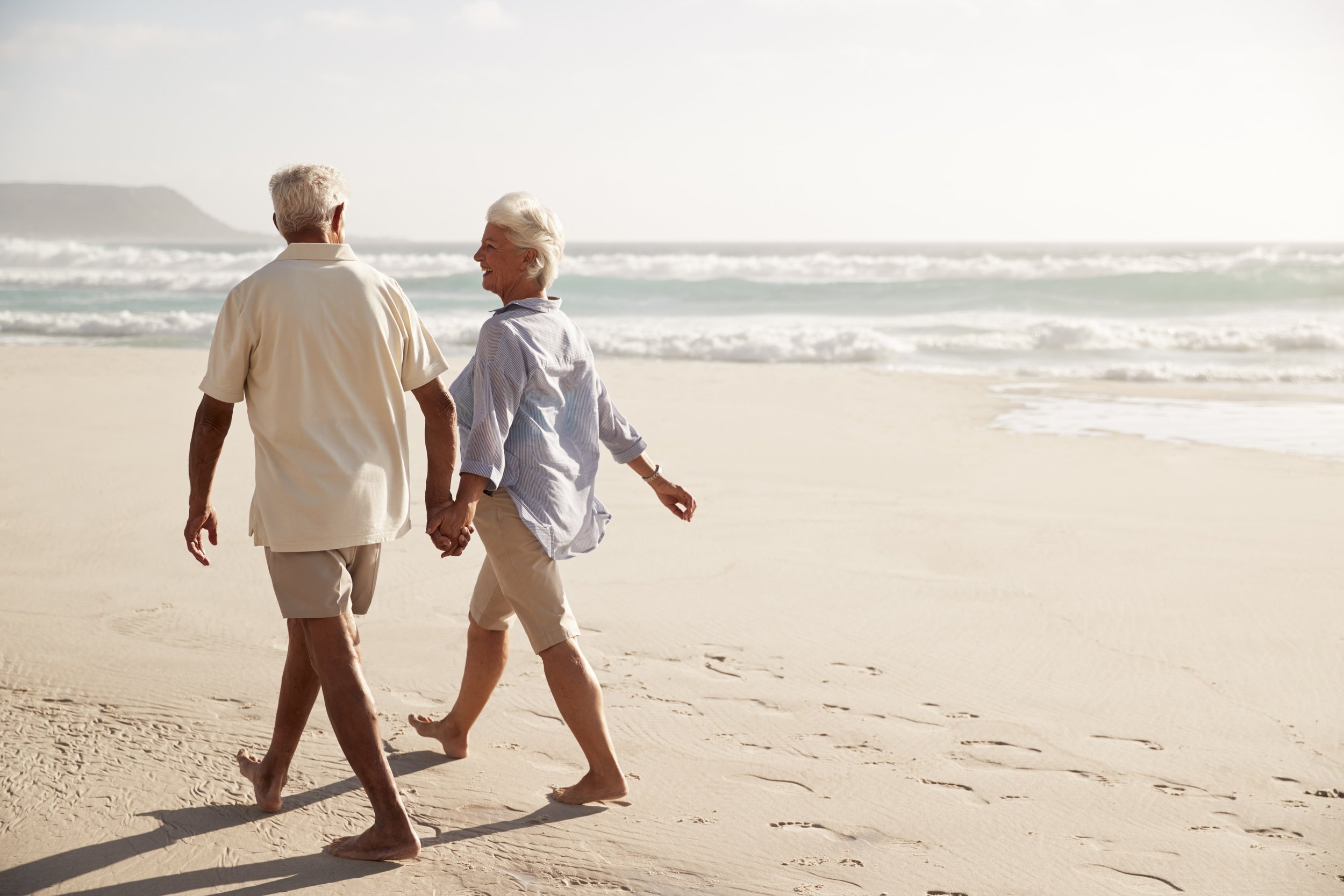 Happy senior couple walking on the beach