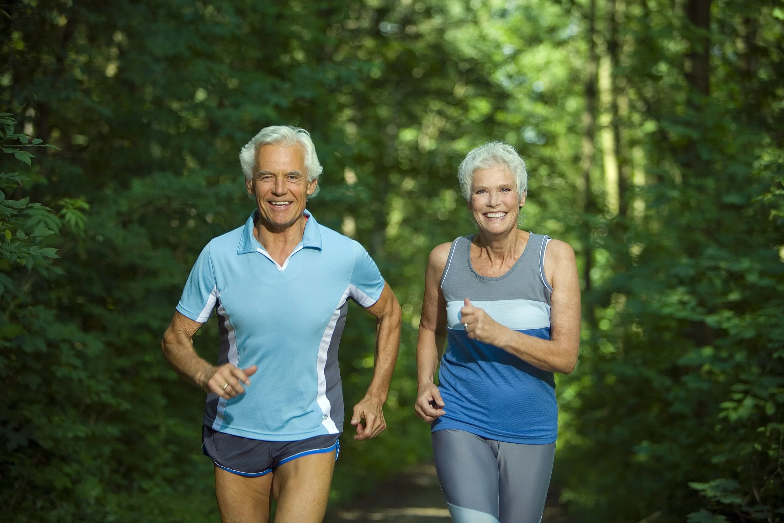 Active senior couple jogging together outdoors
