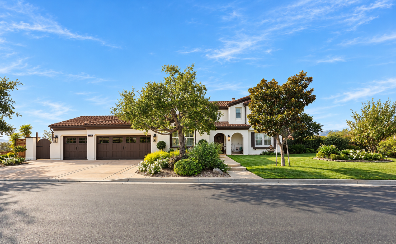 Front exterior of a Fairfield home with white stucco, a tile roof, three-car garage, and landscaped lawn.