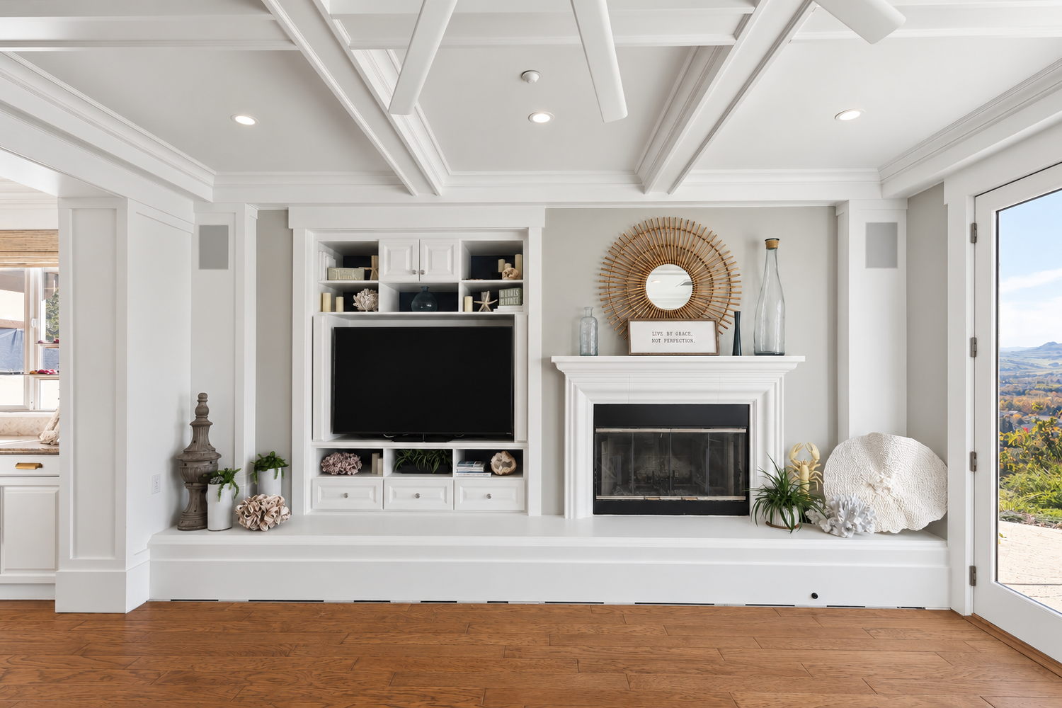White fireplace and built-in television cabinetry beneath a coffered ceiling in a Fairfield family room.