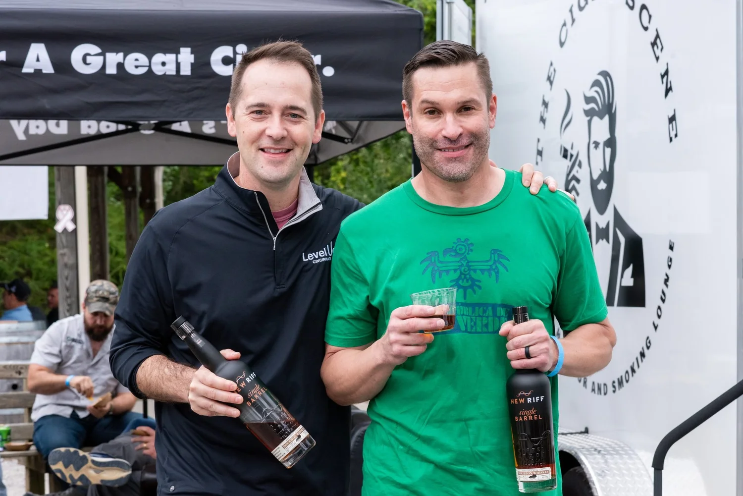 Two guests raise New Riff bourbon at the cigar lounge