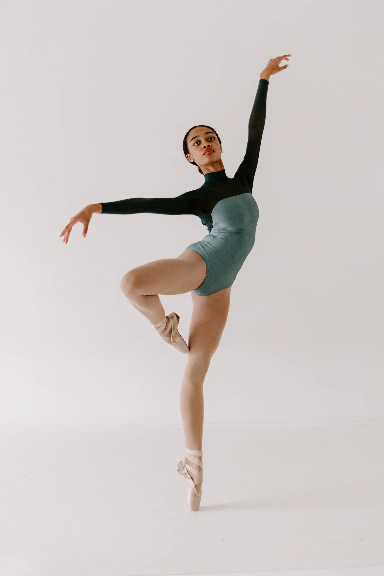 A Rise City Dance dancer on pointe with arms extended