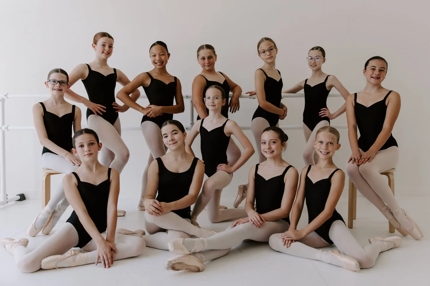 Company 3 dancers posed at the barre