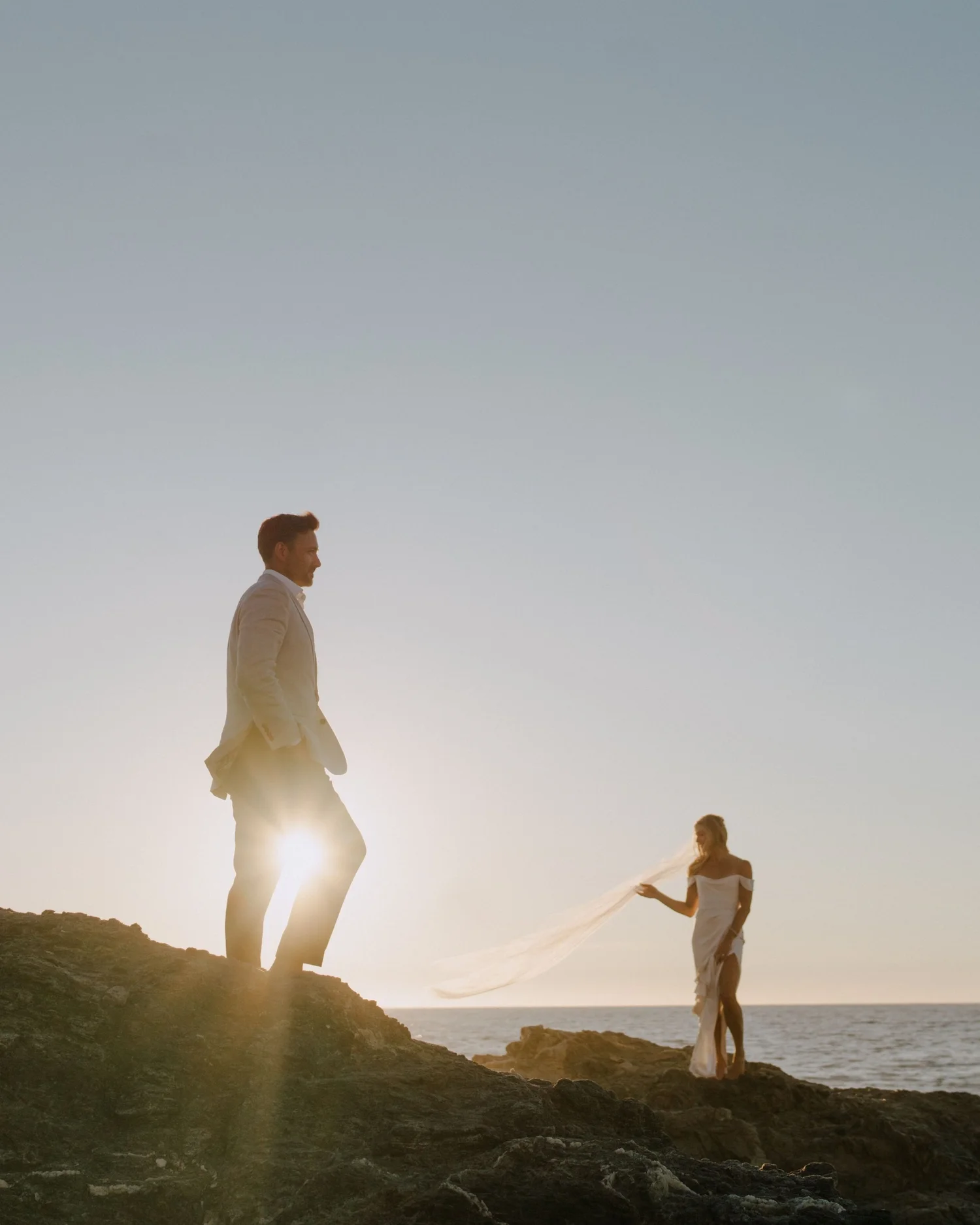 Bride and groom silhouetted against the sunset
