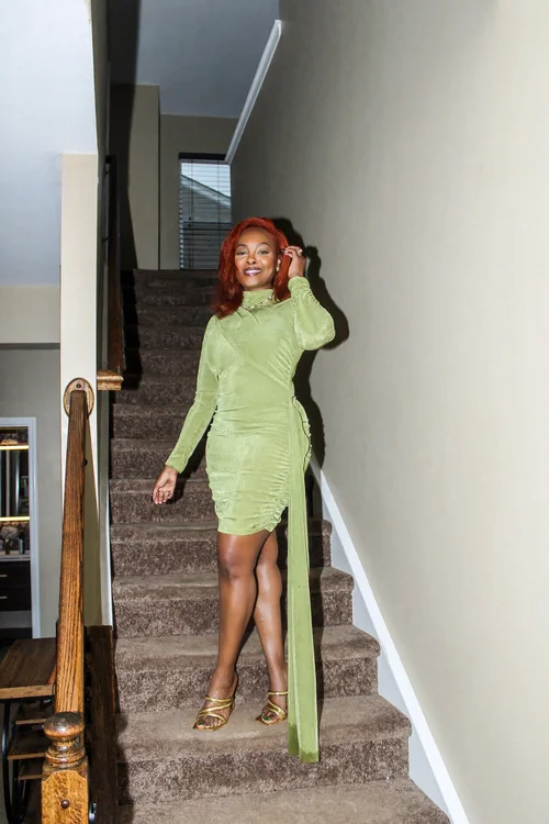 Birthday portrait in a green dress beside the staircase