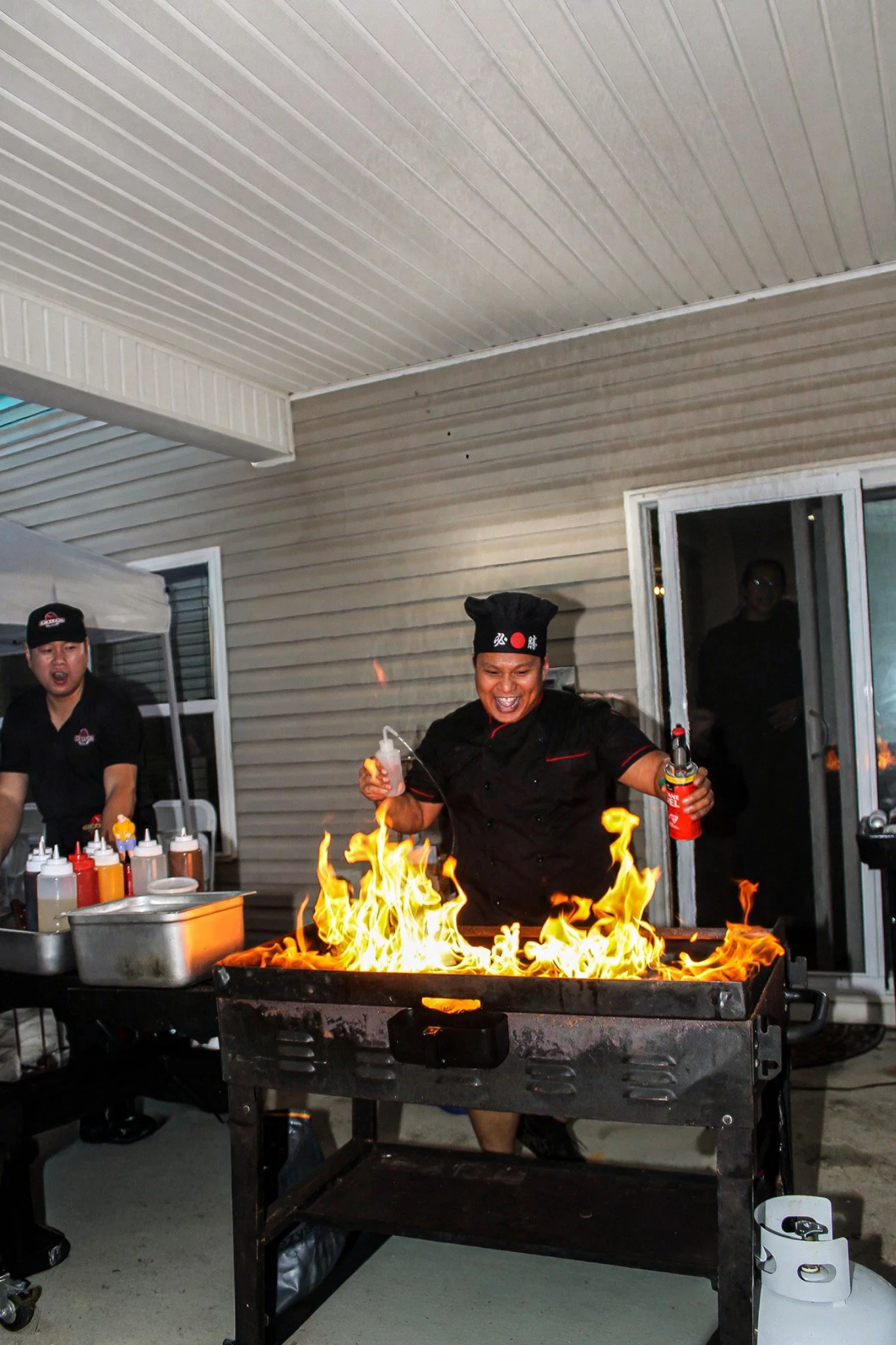 Hibachi chefs tending flames across the grill