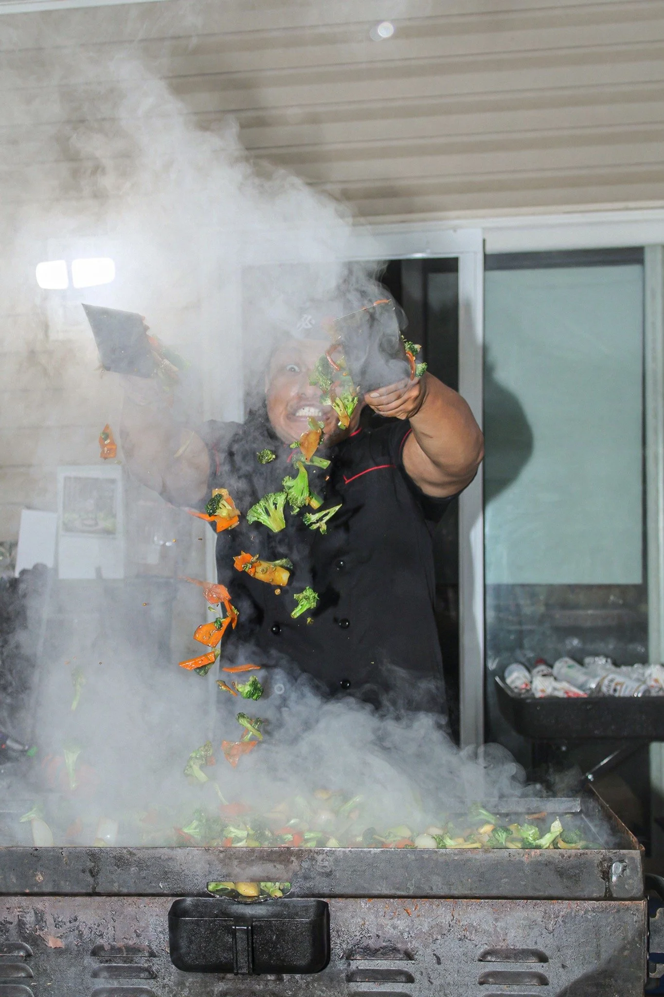 Hibachi chef tossing colorful vegetables