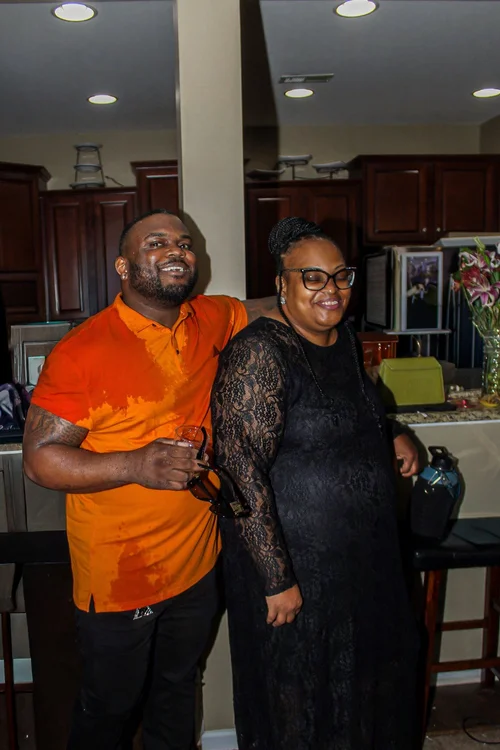 Two guests smiling together in the kitchen