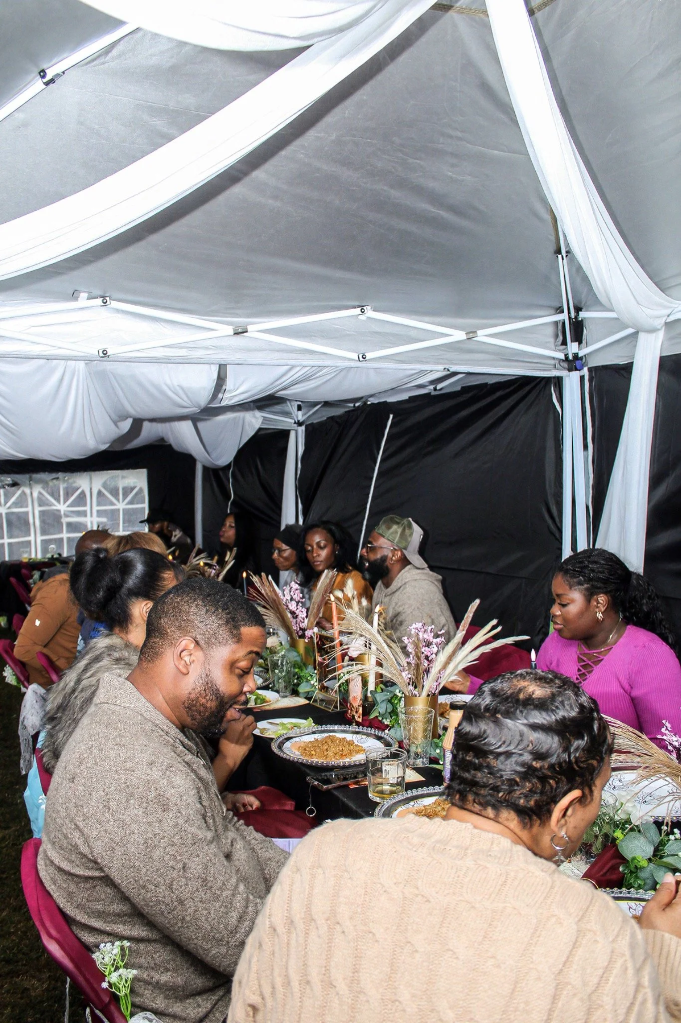 Guests sharing dinner beneath the party tent