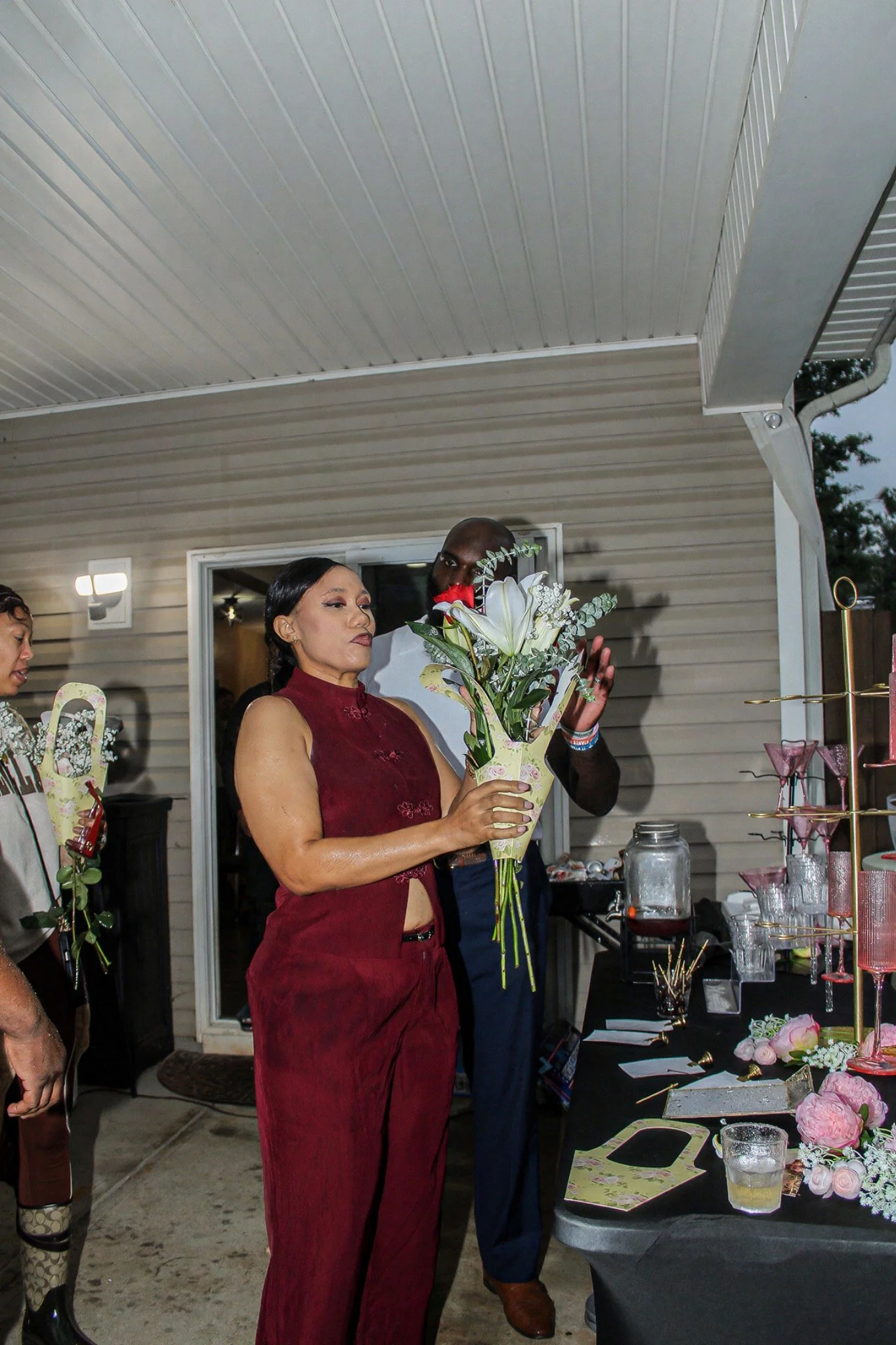 A guest holding a bouquet of flowers at the party