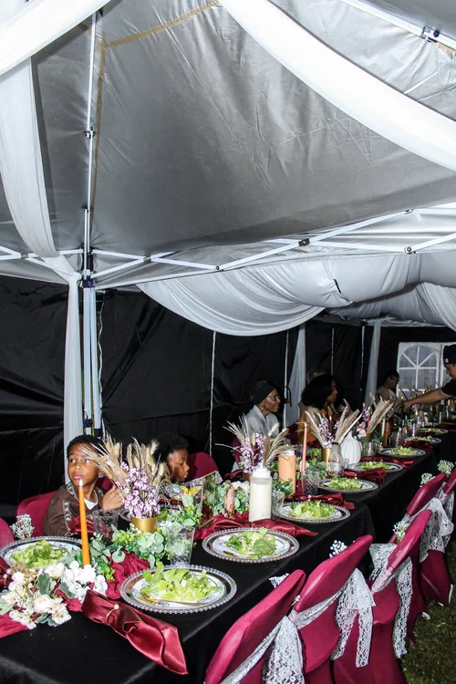 Birthday dining tables beneath white tent draping