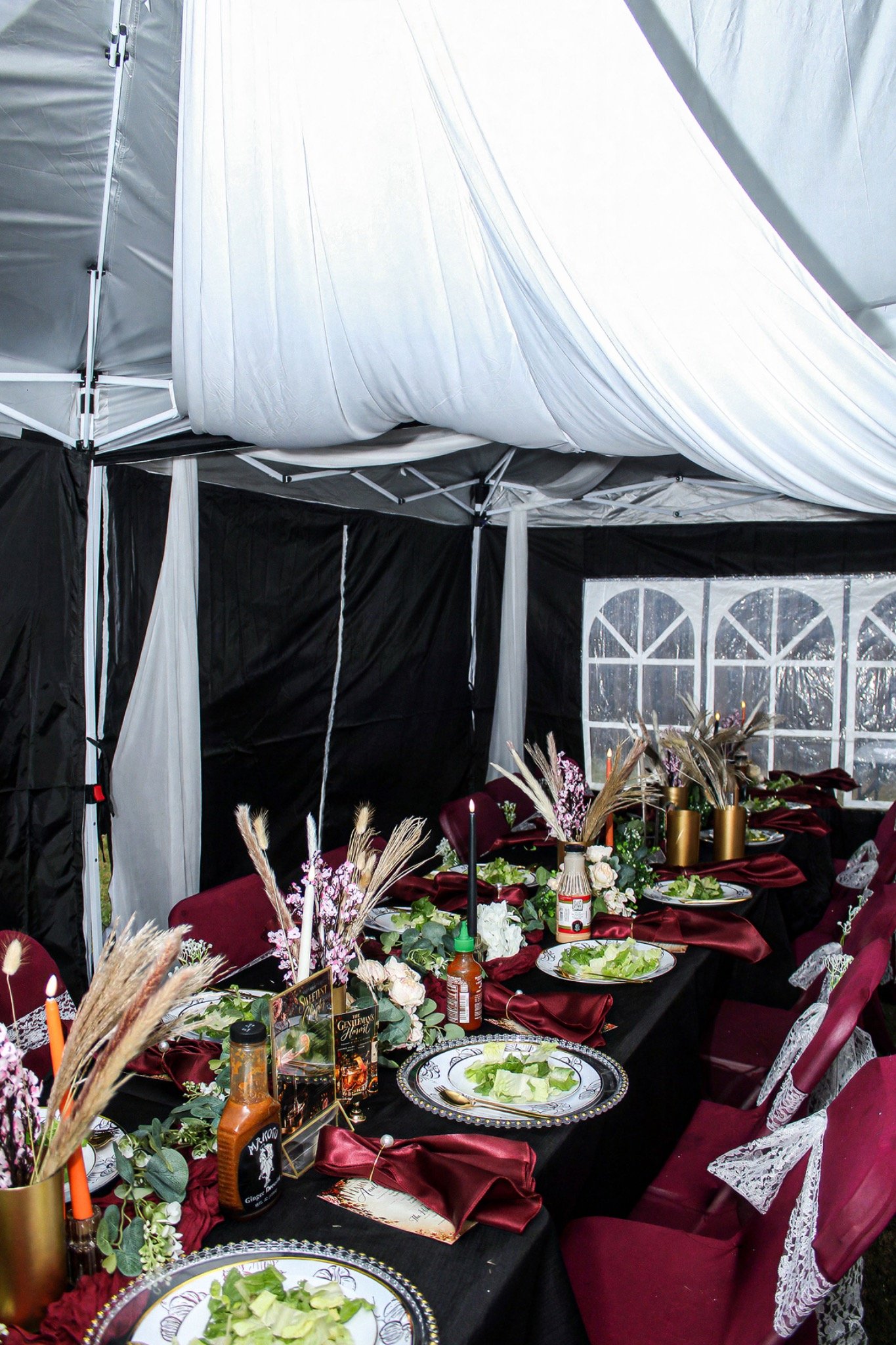Draped party tent with burgundy dining tables