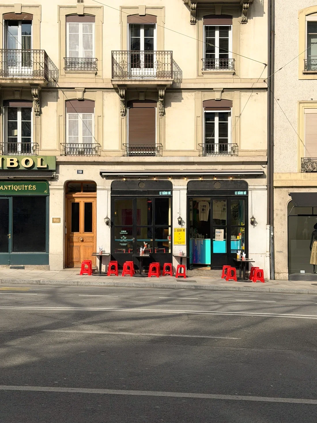 Our restaurant front and red stools in Eaux-Vives