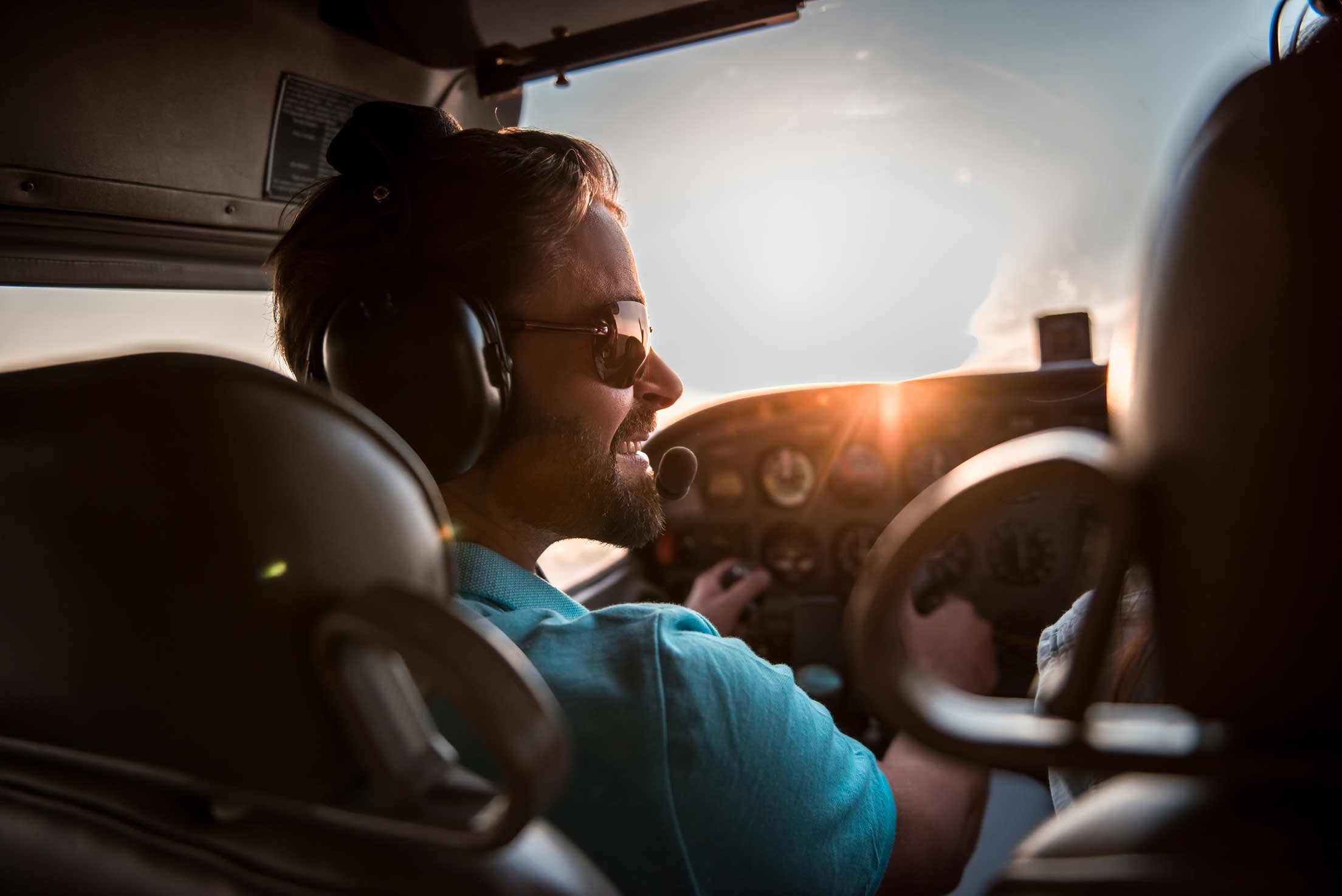 Couple piloting a small aircraft at sunset, enjoying the scenic flight over New Zealand's countryside.