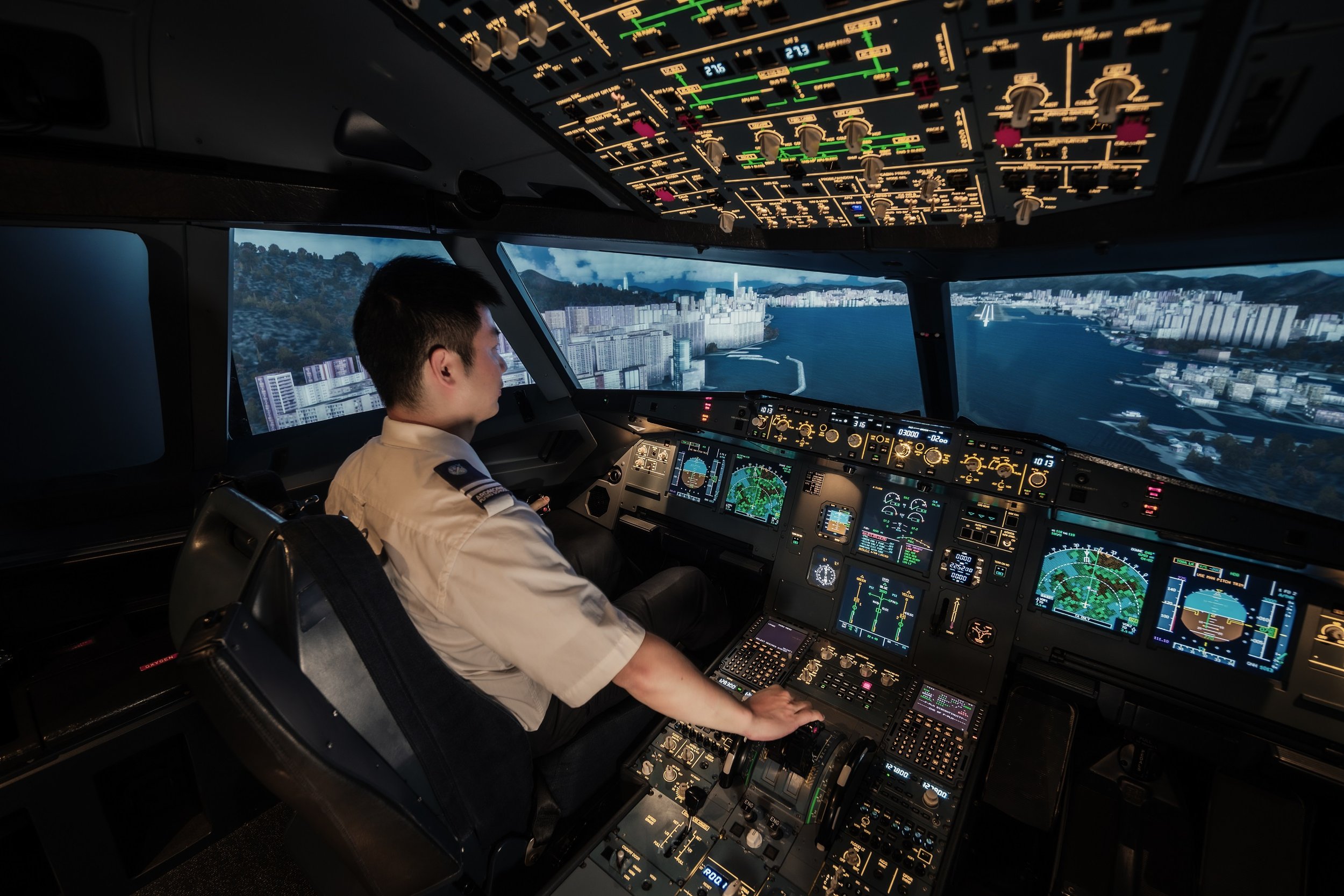 Pilot trainee operating a full-motion Airbus A320 flight simulator in a realistic cockpit environment at Ardmore Flying School.