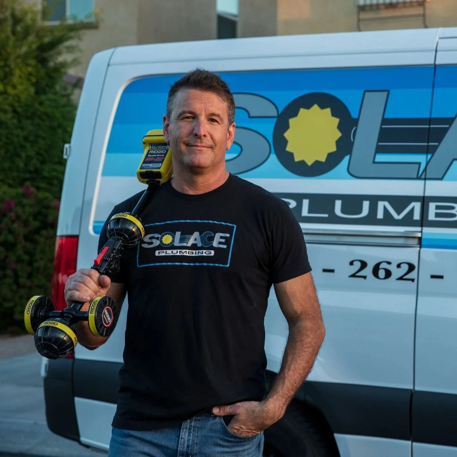 homeowner staring in shock at a water bill with hand on meter