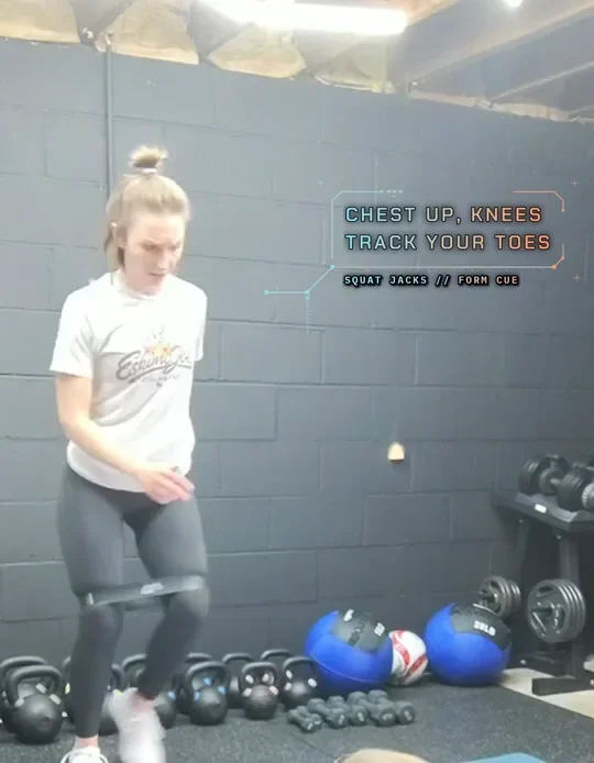 Coach Tabitha doing banded squat jacks with a mini band above her knees, land soft, sit back