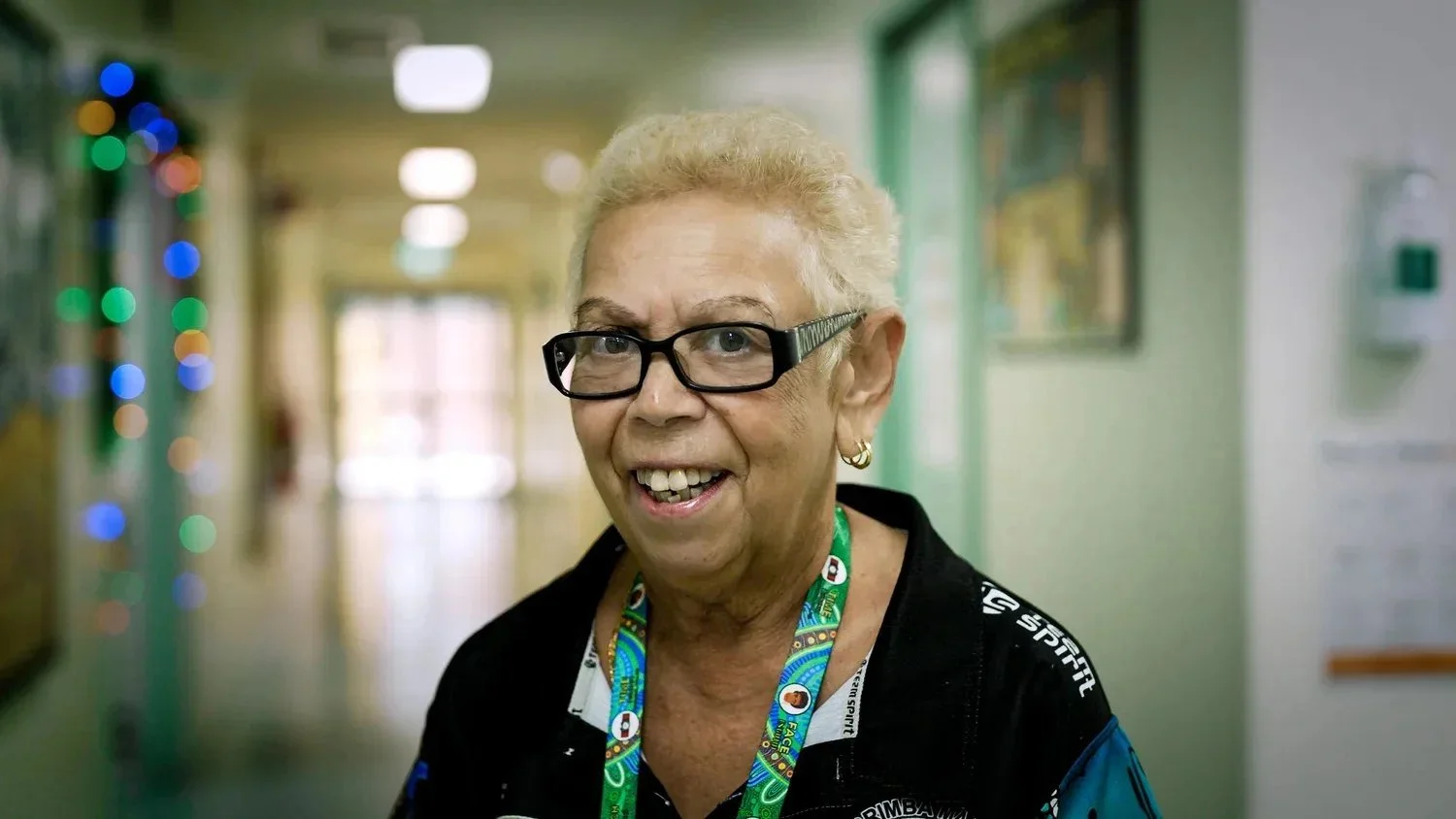 A smiling Elder in a hospital corridor